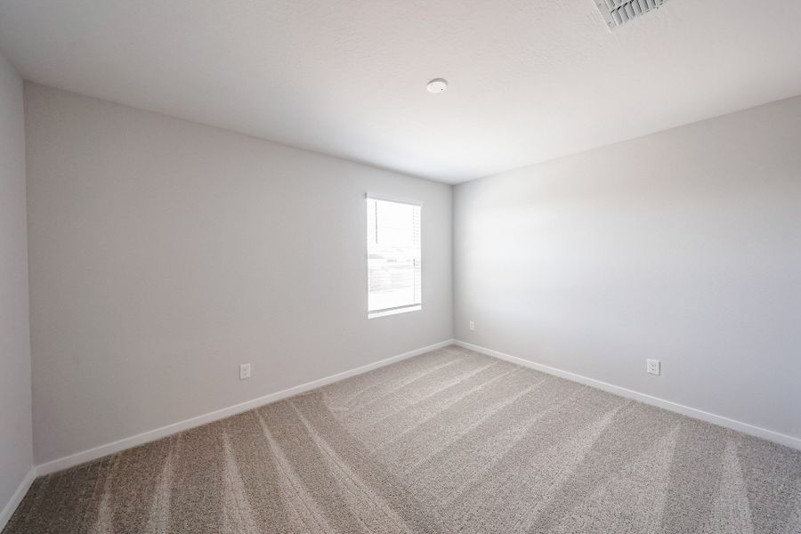 A room with a carpet and a window.