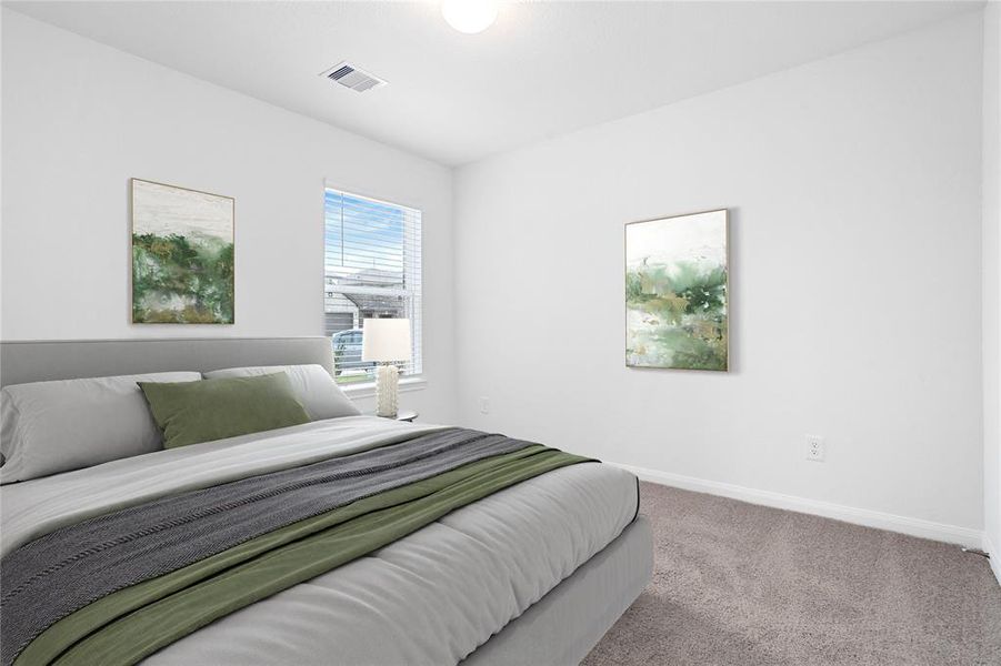 Secondary bedroom features plush carpet, custom paint, large window with privacy blinds and ample closet space.