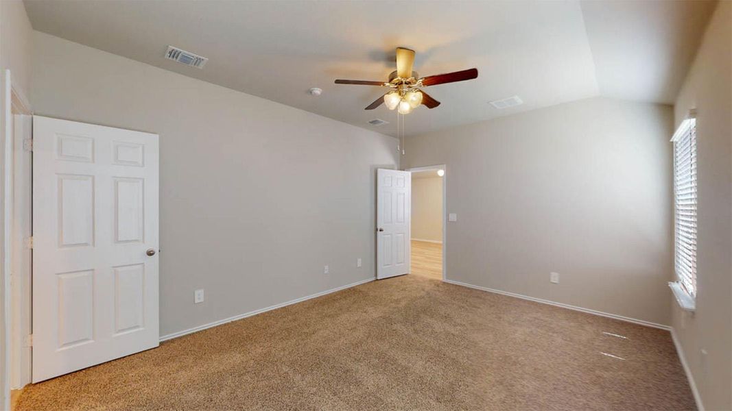 Unfurnished bedroom featuring carpet, ceiling fan, and lofted ceiling