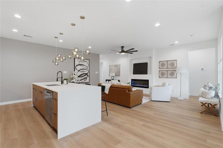 Kitchen featuring open floor plan, an island with sink, ceiling fan, modern cabinets, and wood finish cabinetry Kitchen featuring open floor plan, an island with sink, ceiling fan, modern cabinets, and wood finish cabinetry