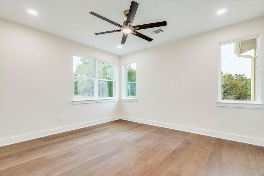 Unfurnished room with light wood-type flooring, healthy amount of natural light, ceiling fan, and recessed lighting
