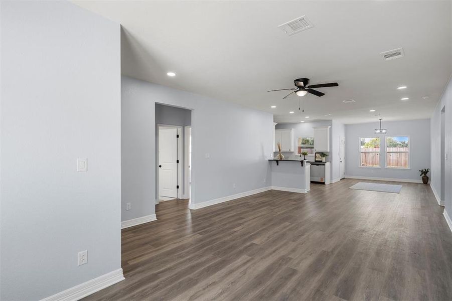 Unfurnished living room featuring recessed lighting, dark wood-style flooring, and a ceiling fan