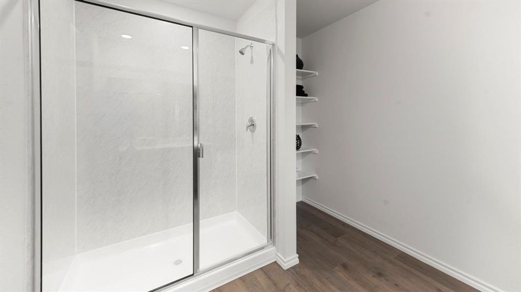 Clear glass shower enclosure with chrome hardware, white shower base, and textured white shower surround Clear glass shower enclosure with chrome hardware, white shower base, and textured white shower surround