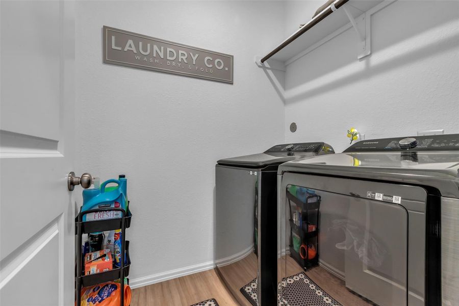 What a nice laundry room. Plenty of room for a large washer and dryers, hanging rod and shelving.