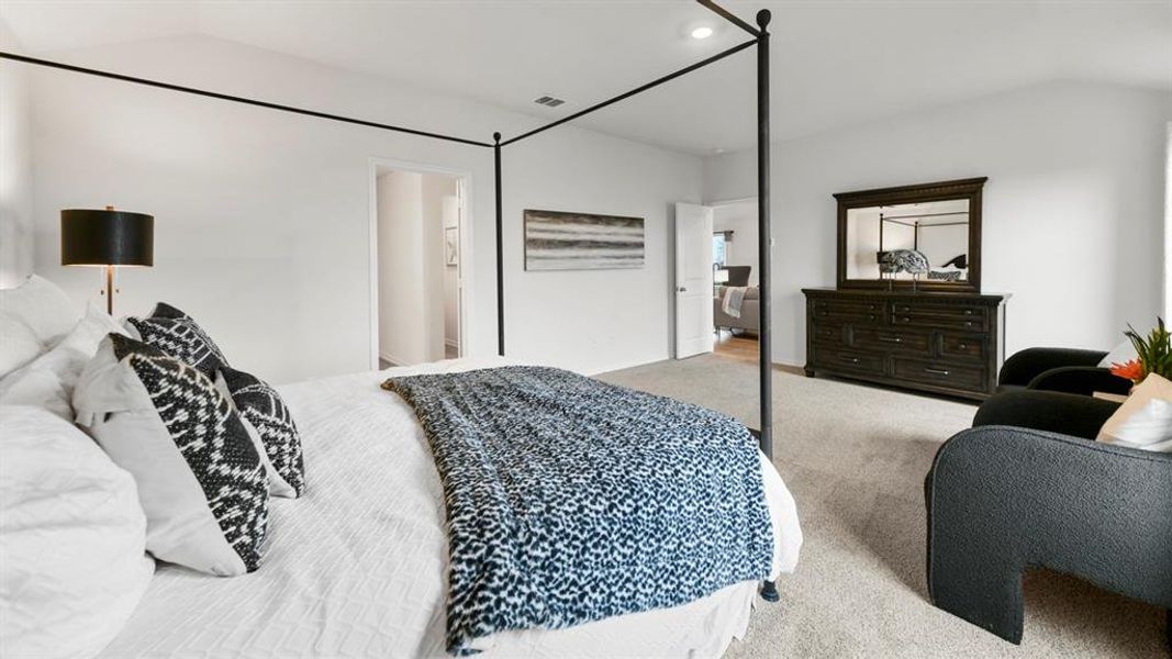 Spacious bedroom featuring light-colored carpeting, white walls, and an open doorway revealing an interior hallway Spacious bedroom featuring light-colored carpeting, white walls, and an open doorway revealing an interior hallway