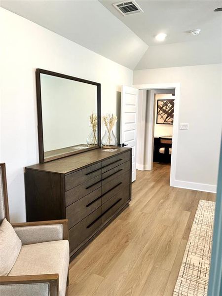 Bedroom featuring light wood-style floors, baseboards, and lofted ceiling Bedroom featuring light wood-style floors, baseboards, and lofted ceiling