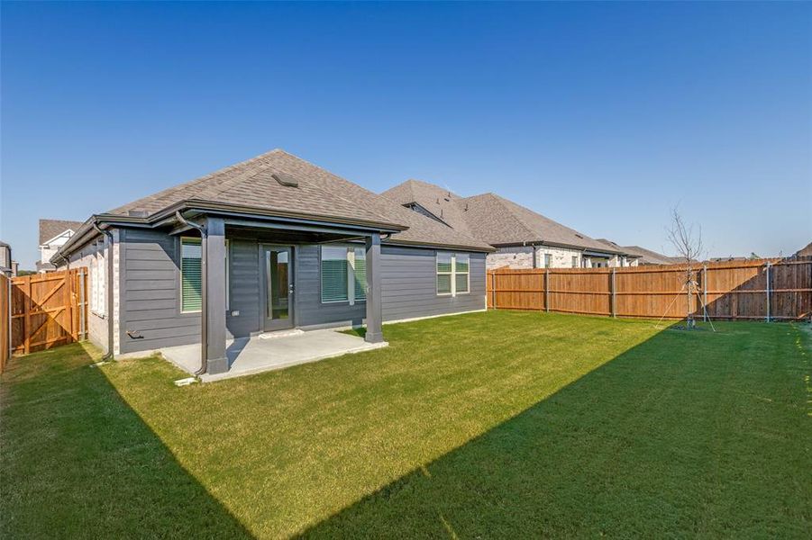 Rear view of house with a patio, a fenced backyard, and roof with shingles
