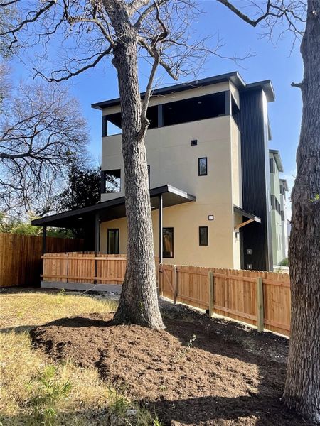 View of home's exterior with a fenced backyard, a balcony, and stucco siding