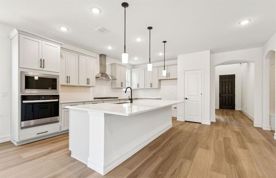 Large island overlooking gathering room and dining areas