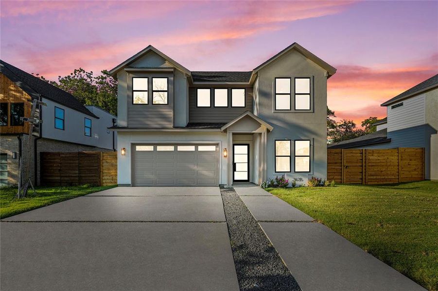 View of front facade with concrete driveway, a garage, a shingled roof, and stucco siding