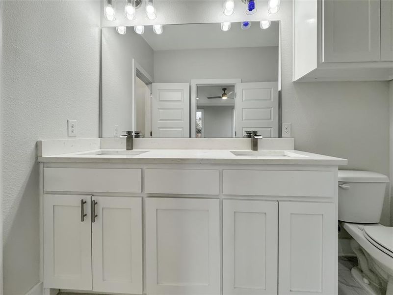Bathroom with double vanity and a textured wall Bathroom with double vanity and a textured wall