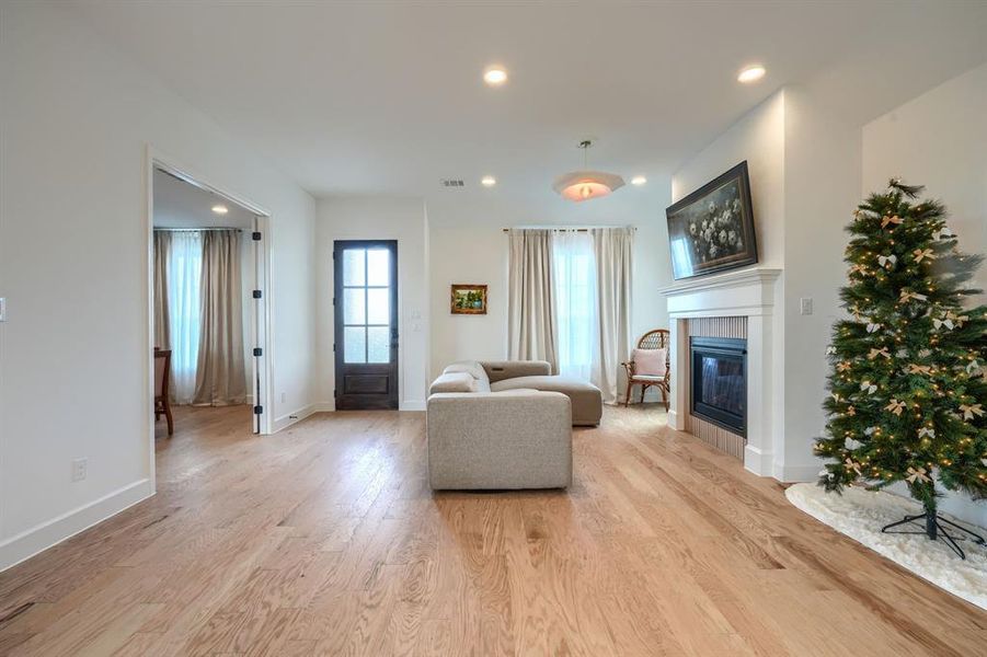 Living room featuring light hardwood / wood-style flooring and a tiled fireplace