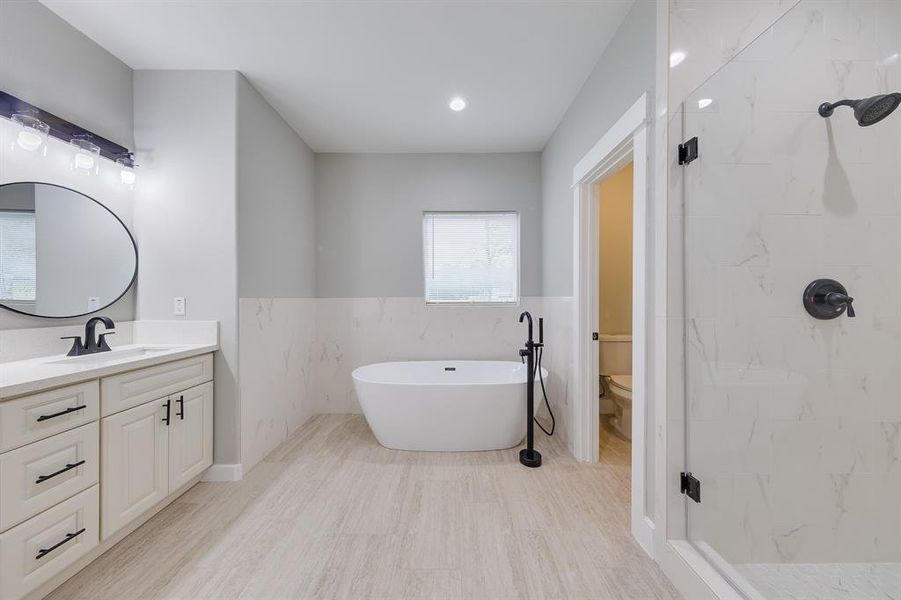 Expansive primary bath with a luxurious soaking tub, dual vanities, and a spacious walk-in shower for ultimate relaxation.