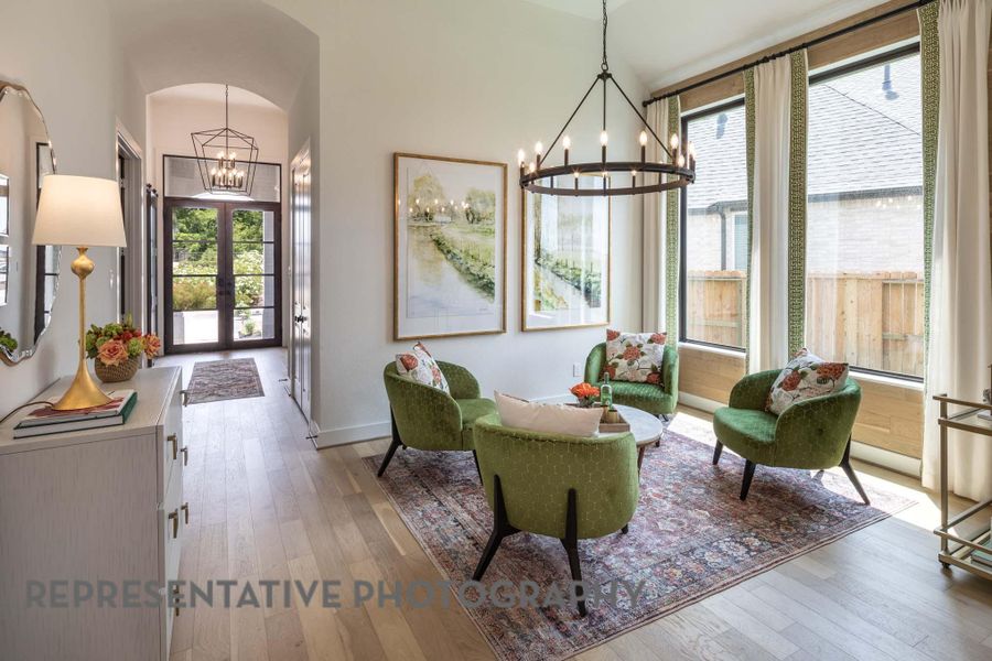 Sitting room featuring plenty of natural light, wood-type flooring, and a chandelier Sitting room featuring plenty of natural light, wood-type flooring, and a chandelier