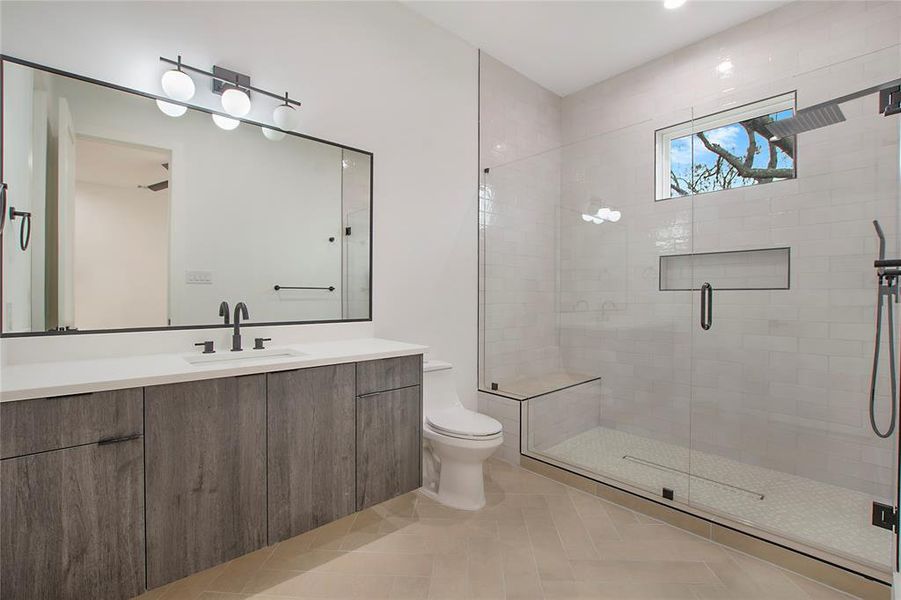 Bathroom featuring tile patterned floors, vanity, toilet, and a shower with shower door