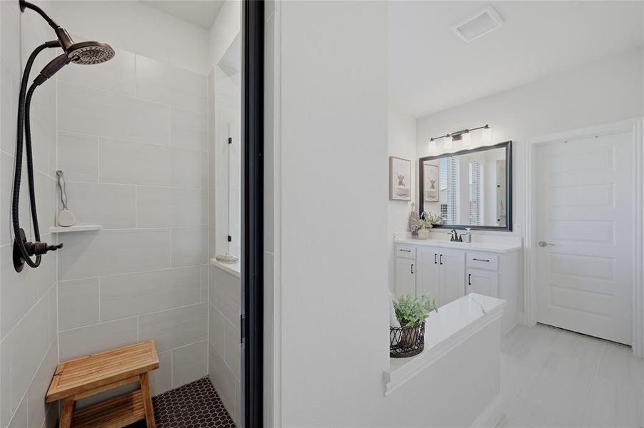 Bathroom featuring a walk-in shower with vertical tile surround and dark penny tile flooring, a dark bronze shower fixture, and a built-in shower shelf
