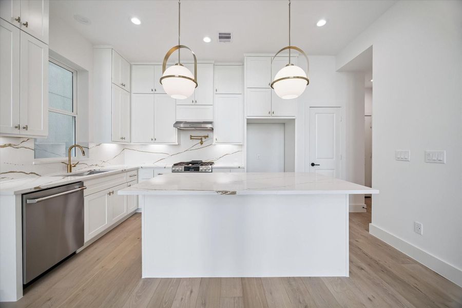 this home Features package a with beautiful gold finishes, White and gold quartz and gold plumbing fixtures. The cabinets are Kenmore, soft clothes, and extend all the way to the ceiling.