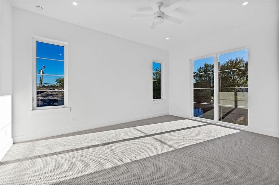 Carpeted empty room featuring a wealth of natural light and ceiling fan