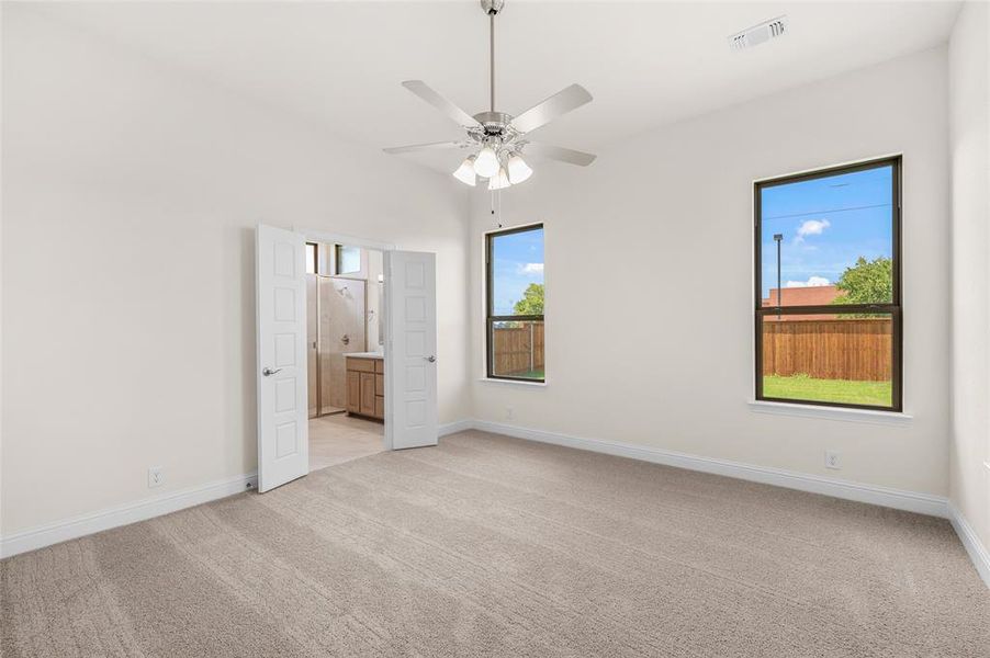 Unfurnished bedroom with light carpet, ceiling fan, and connected bathroom Unfurnished bedroom with light carpet, ceiling fan, and connected bathroom