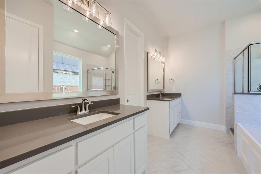 Bathroom featuring a tub, dual bowl vanity, and tile floors