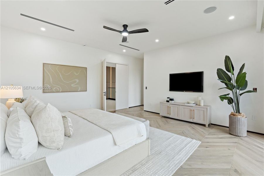 Herringbone-patterned wood-finish flooring, recessed linear lighting, and integrated ceiling speakers