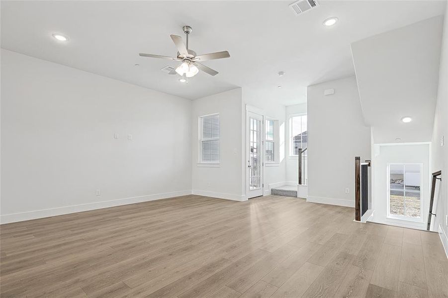 The property features a spacious room with light wood-style flooring and white walls