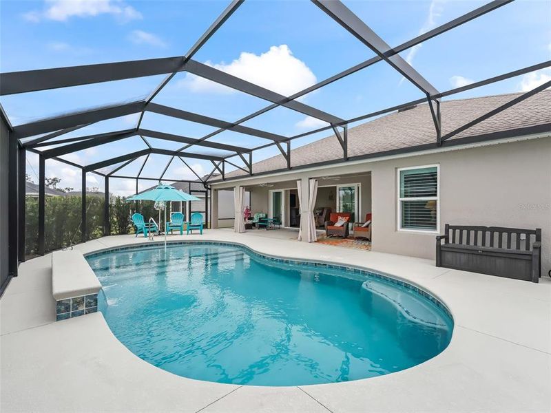 Pool area with expanded patio space, shallow shelf with umbrella, and three waterfalls