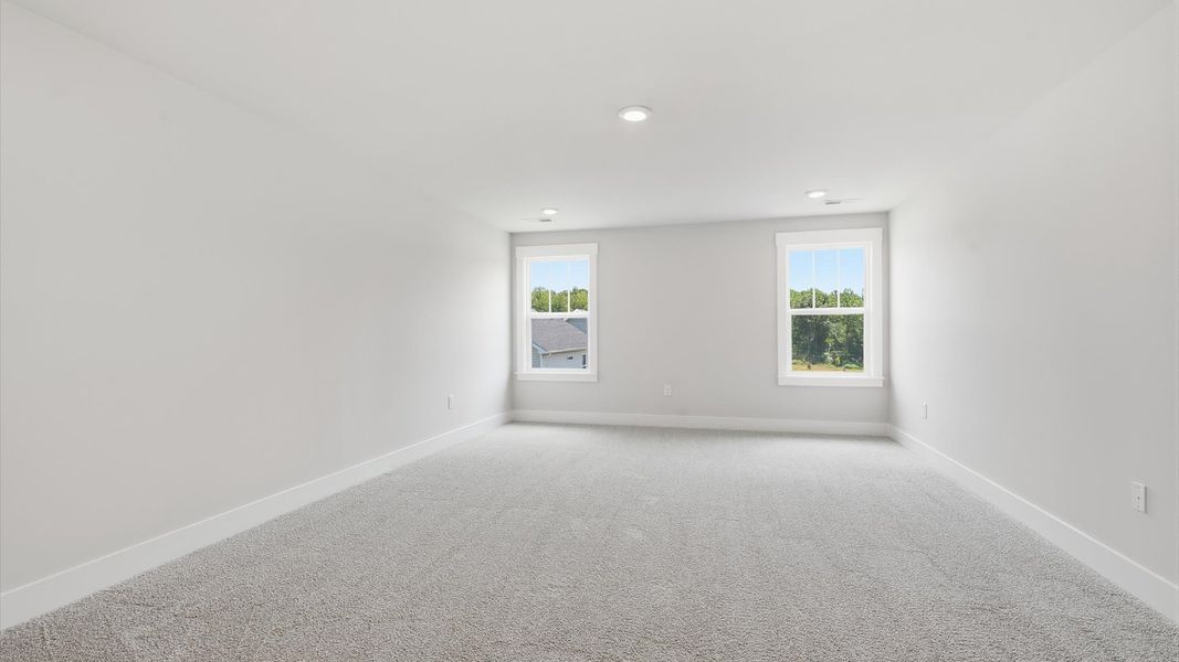 Functional bonus room with carpeted floors and exceptional natural light in a modern home Functional bonus room with carpeted floors and exceptional natural light in a modern home