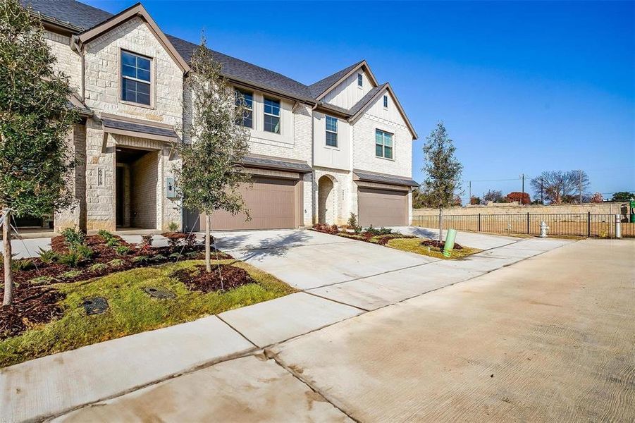 View of front facade with a garage, stone siding, concrete driveway, brick siding, and roof with shingles View of front facade with a garage, stone siding, concrete driveway, brick siding, and roof with shingles