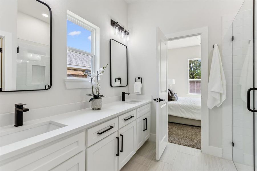 Bathroom featuring tile patterned floors, vanity, and walk in shower