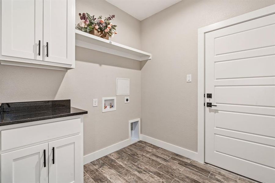 Washroom featuring hookup for a washing machine, dark hardwood / wood-style flooring, electric dryer hookup, and cabinets