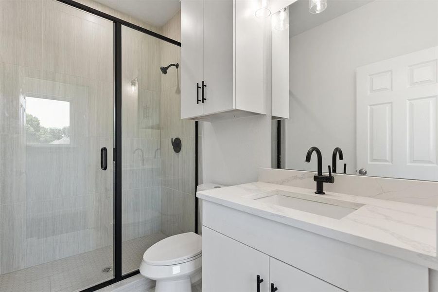 Full bath with a stall shower, toilet, and vanity Full bath with a stall shower, toilet, and vanity
