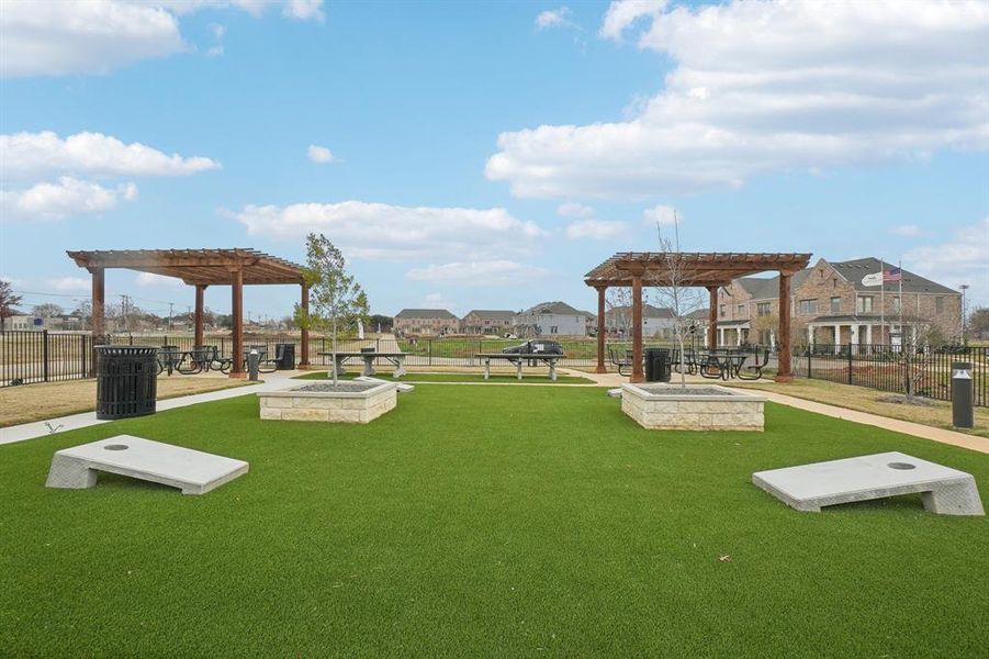 View of property's community featuring a pergola and a lawn