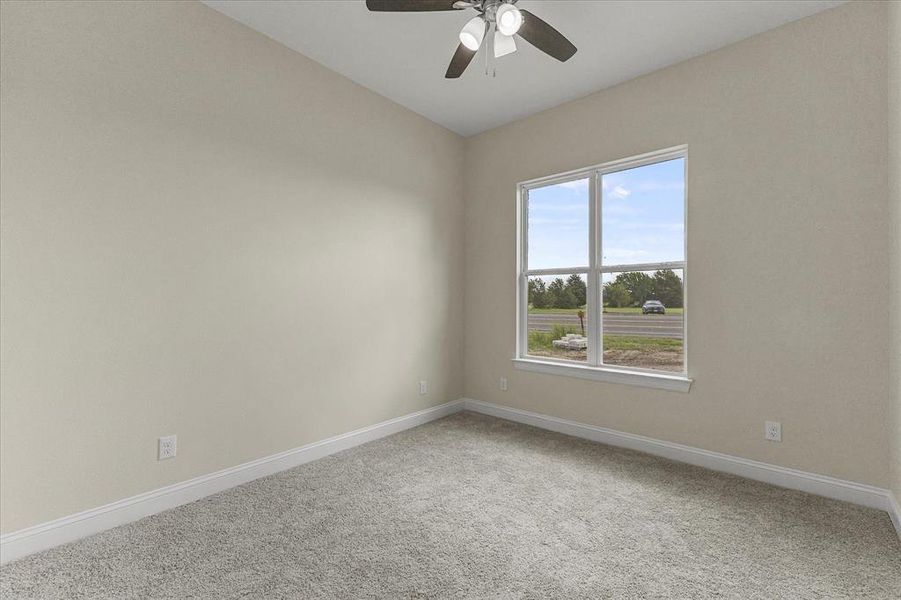 Carpeted spare room with a ceiling fan and lofted ceiling
