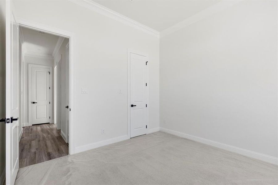 Carpeted bedroom featuring crown molding