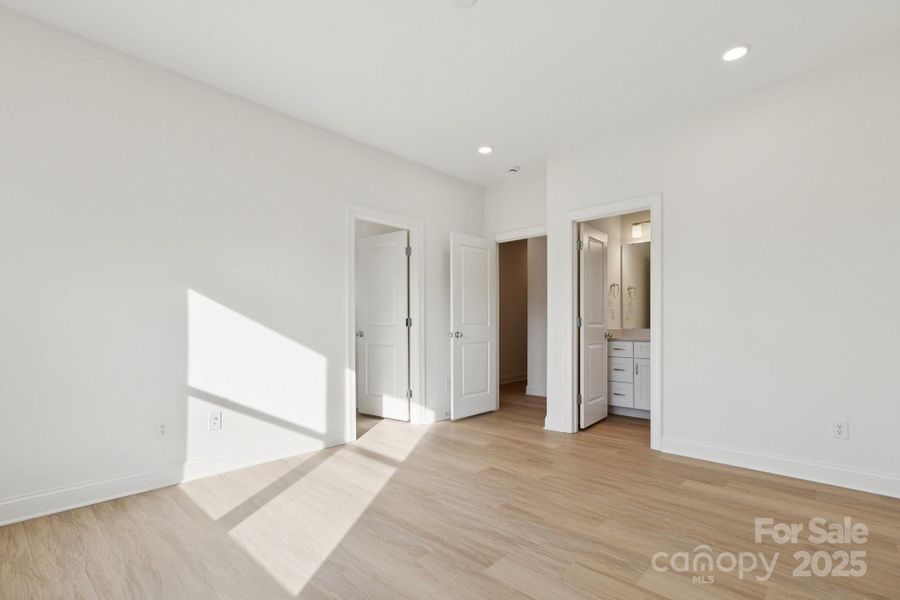 Large primary bedroom with huge walk-in closet and en-suite bathroom complete with a tiled shower wall Large primary bedroom with huge walk-in closet and en-suite bathroom complete with a tiled shower wall