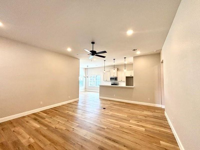 Unfurnished living room featuring light wood-type flooring and ceiling fan