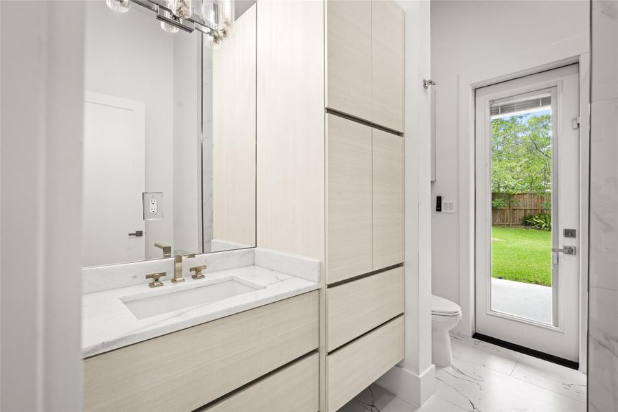 Heading back downstairs, a convenient full “pool” bathroom with direct backyard access features a spacious walk-in shower & ample storage. Heading back downstairs, a convenient full “pool” bathroom with direct backyard access features a spacious walk-in shower & ample storage.