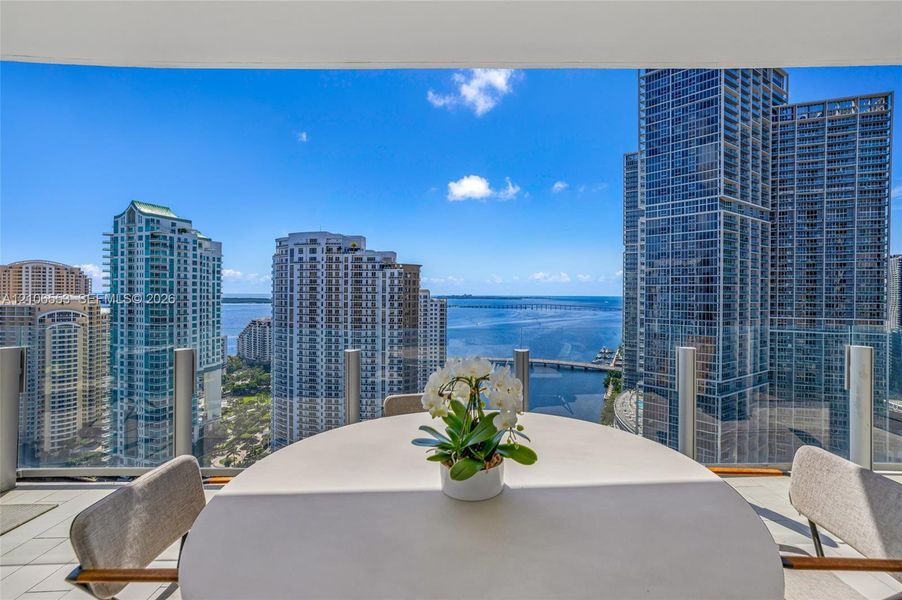 Covered balcony featuring glass railing panels and light-toned tile flooring