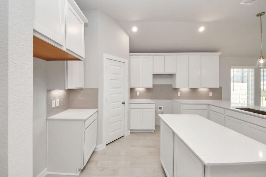 This generously spacious kitchen is a dream realized! With a massive granite island, high ceilings, soft close cabinets, granite countertops, stainless steel appliances, a sleek tile backsplash, recessed lighting, and an extended counter area, it offers both style and practicality. All this opens up to the expansive family room, creating a perfect hub for gatherings. Sample photo of completed home with similar floor plan. Actual colors and selections may vary. This generously spacious kitchen is a dream realized! With a massive granite island, high ceilings, soft close cabinets, granite countertops, stainless steel appliances, a sleek tile backsplash, recessed lighting, and an extended counter area, it offers both style and practicality. All this opens up to the expansive family room, creating a perfect hub for gatherings. Sample photo of completed home with similar floor plan. Actual colors and selections may vary.