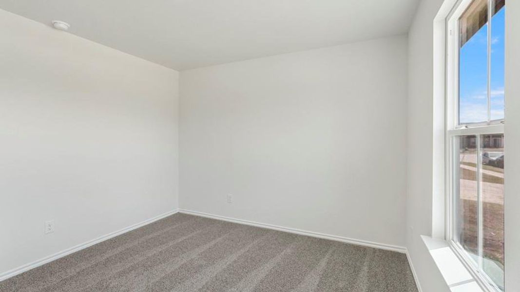 Carpeted room featuring a double-hung window, white walls, and baseboards