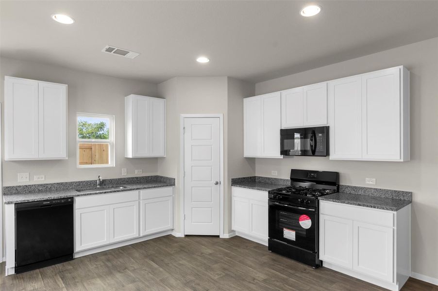 Kitchen with black appliances, dark wood finished floors, white cabinets, and recessed lighting Kitchen with black appliances, dark wood finished floors, white cabinets, and recessed lighting