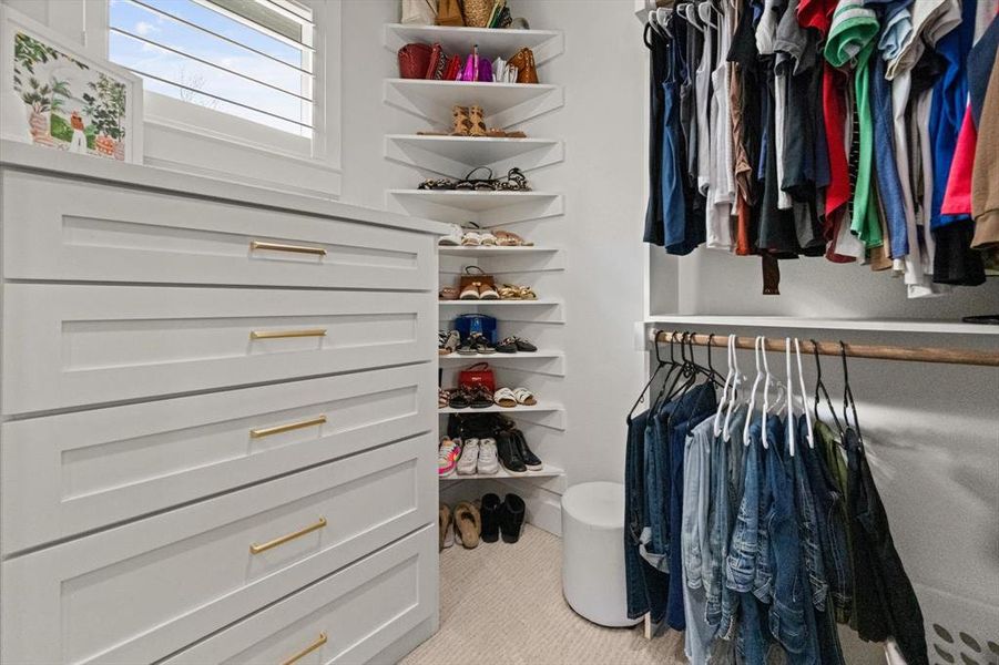 HIS & HERS Walk in closets featuring built in drawers and organizational shelving