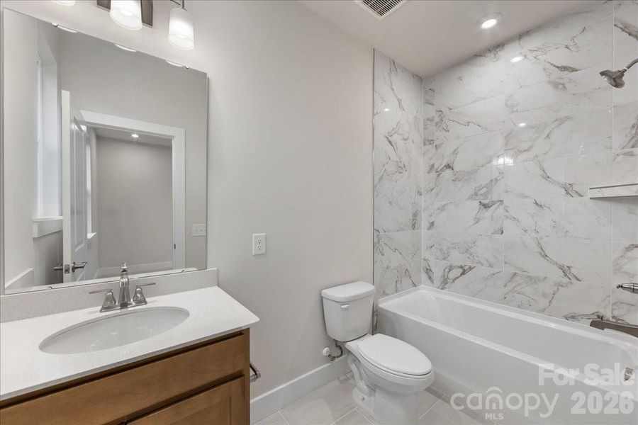 Secondary bathroom with tiled walls above the tub