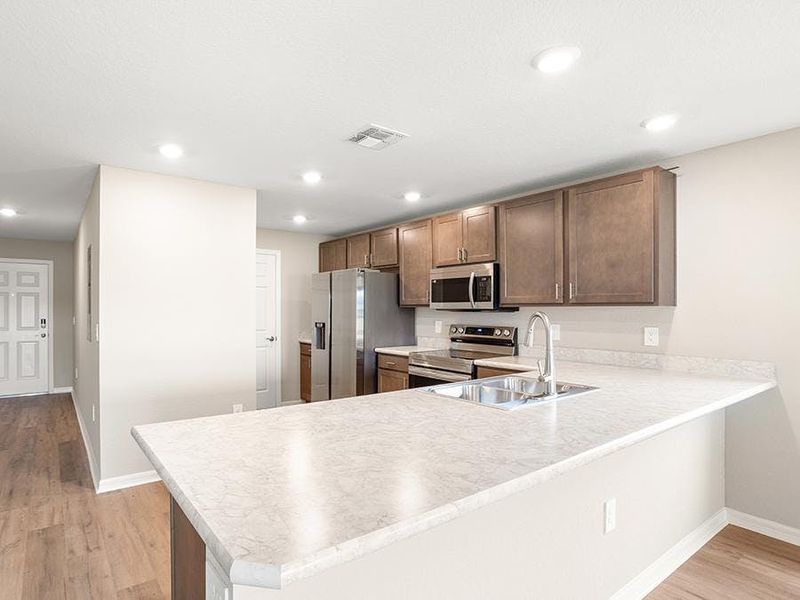 Your new kitchen includes modern conveniences and in-kitchen dining at the bar - Bimini townhome by Highland Homes