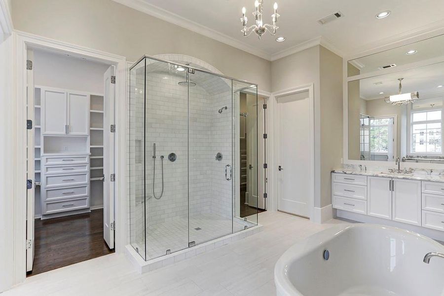 *PREVIOUS SPEC* Representative of a Jeff Paul Custom Homes primary suite bath featuring separate vanities, soaking tub and walk-in glass shower.