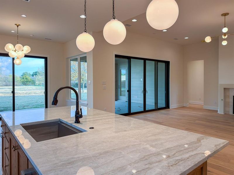 Kitchen island featuring a single-basin sink with a matte black gooseneck faucet