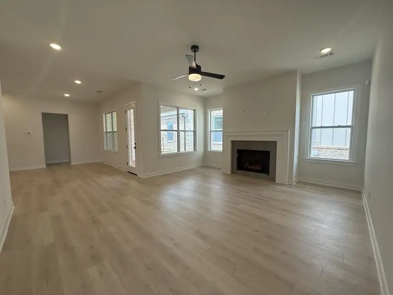 Unfurnished living room with a ceiling fan, recessed lighting, a fireplace, and light wood-style flooring