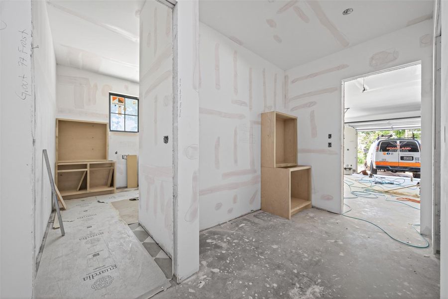 Garage entrance features a drop zone with mud bench and custom cabinetry built on site