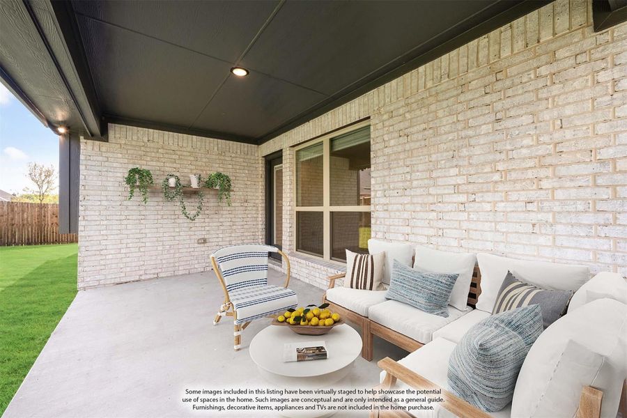 Covered back patio with brick exterior wall, outdoor seating, and view of green backyard